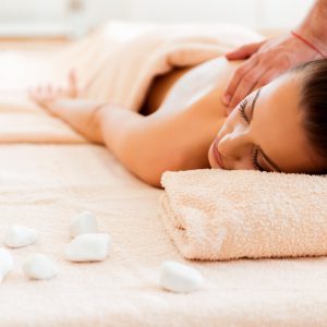 Hot stone relaxation Beautiful young woman receiving a hot stone treatment at a spa.